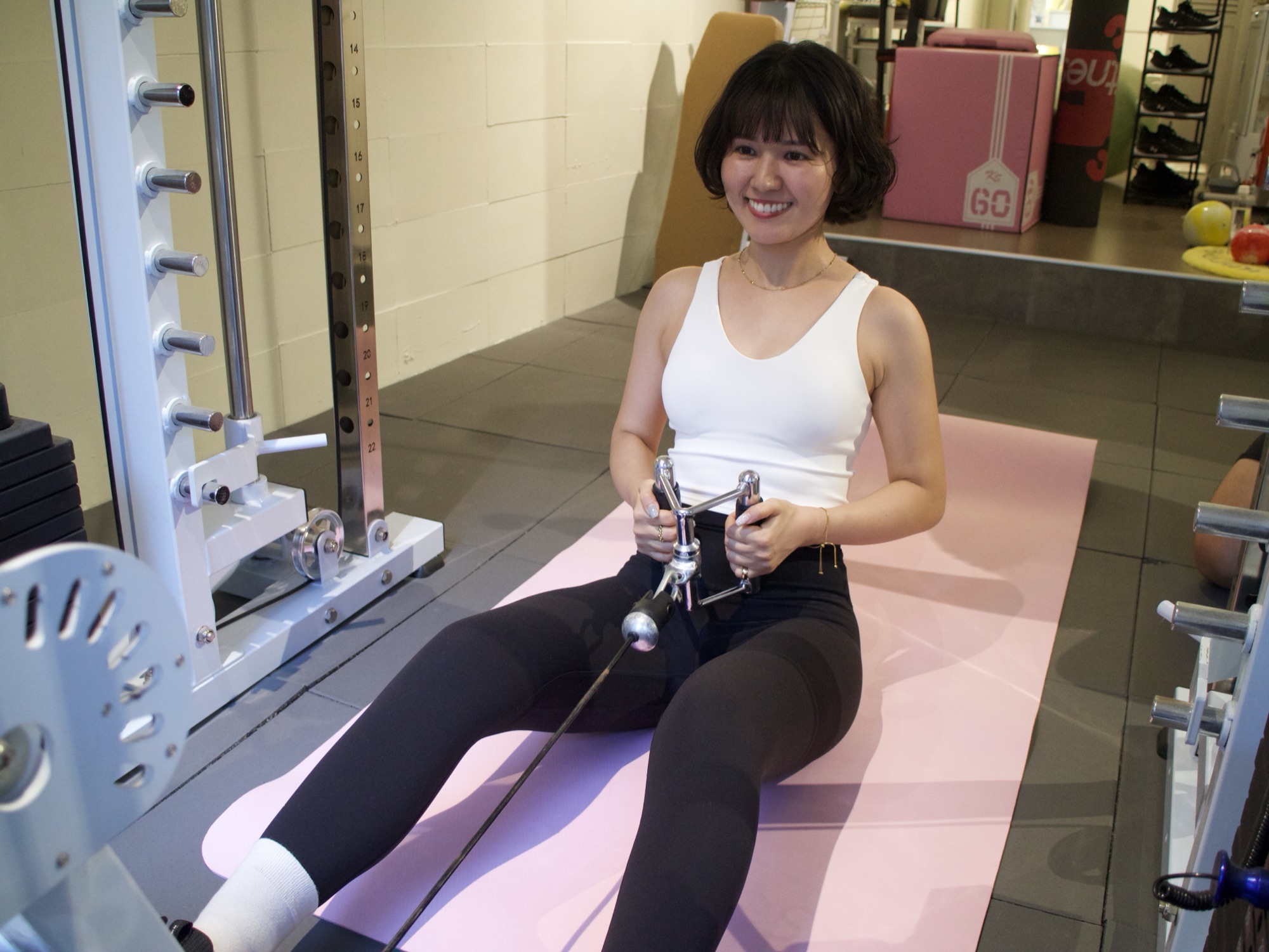 ケーブルマシンを使いながら笑顔でトレーニングするお客様